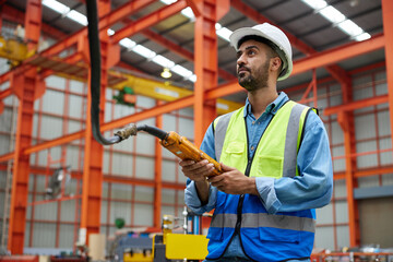 worker or engineer operating remote switch to control machine in the factory