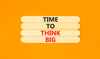 Time to think big symbol. Concept words Time to think big on wooden stick. Beautiful orange table orange background. Business and time to think big concept. Copy space.