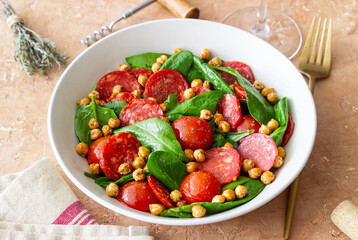 Salad with spinach, sausage, tomatoes and chickpeas. Healthy eating. Diet.