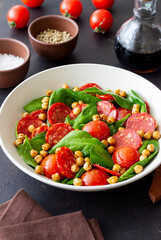 Salad with spinach, sausage, tomatoes and chickpeas. Healthy eating. Diet.