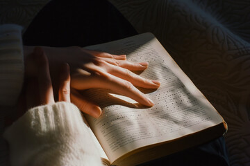 Hand of blind person reading a book in braille system