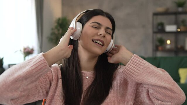 One woman with headphones at home listen music online happy smile sing