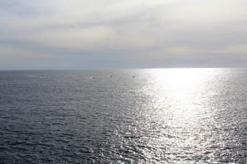 Obraz premium blue sky over calm gentle sea with sun glare