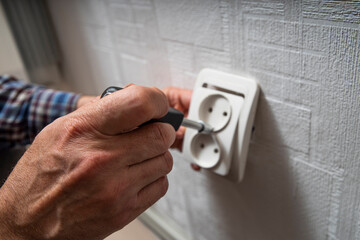Installation or repair of electrical outlet socket box within the wall. Serviceman or repairman...