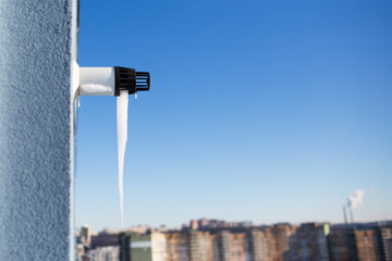 Close-up of icicle on gas boiler chimney in winter time. Flue of gas boiler in apartment.