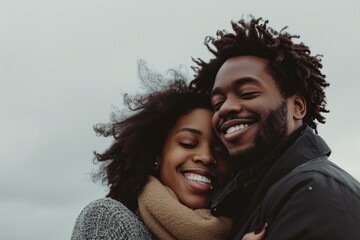 Happy couple embracing outdoors on a cloudy day.