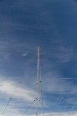 Radio mast against blue sky with cloud, copyspace. - 731218467
