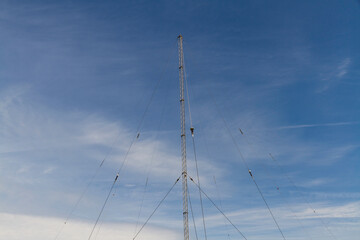 Radio mast against blue sky with cloud. - 731218498