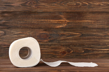 Roll of toilet paper on wooden background