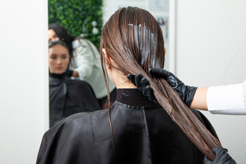 Photo of a European girl with long and beautiful brunette hair at the beauty salon. Shiny and healthy hair