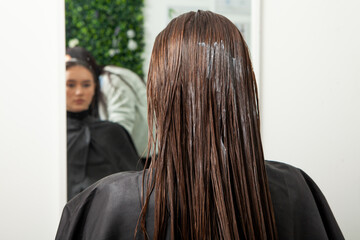 Photo of a European girl with long and beautiful brunette hair at the beauty salon. Shiny and...