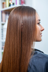 Photo of a European girl with long and beautiful brunette hair at the beauty salon. Shiny and healthy hair