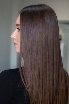 Photo of a European girl with long and beautiful brunette hair at the beauty salon. Shiny and healthy hair