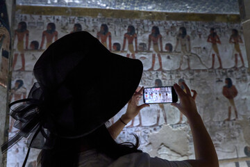 a tourist shooting King Seti tomb at the Valley of Kings .Luxor . Egypt. Hieroglyphics in King Seti...
