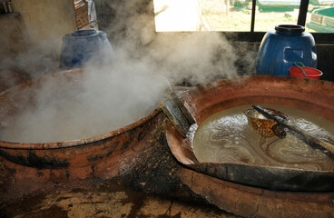 Sugar cane juice boiling in artisanal clay ovens to Artisanal brown sugar production and candies....