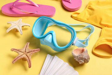 Set of beach accessories with starfishes on color background