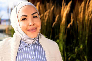 portrait of smiling woman in hijab. Beautiful nature of the Norwegian park