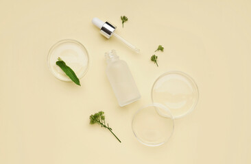 Petri dishes with herbs and bottle of cosmetic product on yellow background