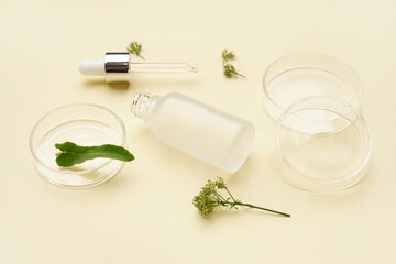 Petri dishes with herbs and bottle of cosmetic product on yellow background