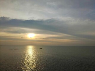 a walkway extending out over the ocean The sky is blue and there are some white clouds.