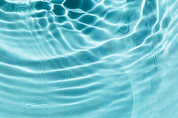 Textured background of light blue water with sun reflections. Concept of tranquility and natural...