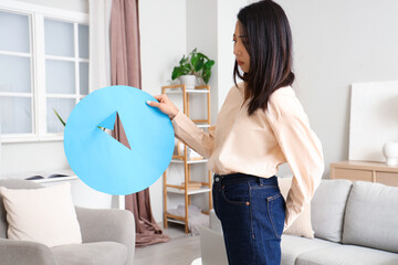 Young Asian woman with hemorrhoids and paper thumbtack at home