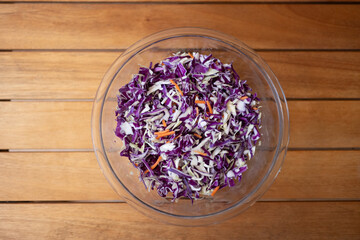 Clear glass bowl of healthy, colorful cabbage.