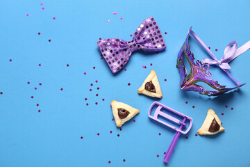 Composition with Hamantaschen cookies, carnival mask, bow and rattle for Purim celebration on color background