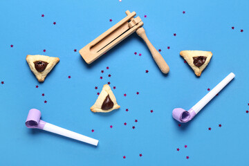 Composition with Hamantaschen cookies, rattle and party whistles for Purim celebration on color...