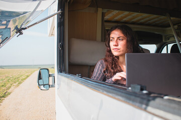 Digital nomad girl works on her computer from her motorhome.