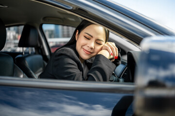 Young beautiful asian business women getting new car. Happy smiling female driving vehicle on the road hugging steering wheel touching detail car interior. Business woman buying driving new car