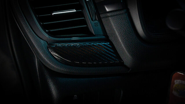 Detalles interiores en consola central de vehículo con detalles en vinilo fibra de carbono