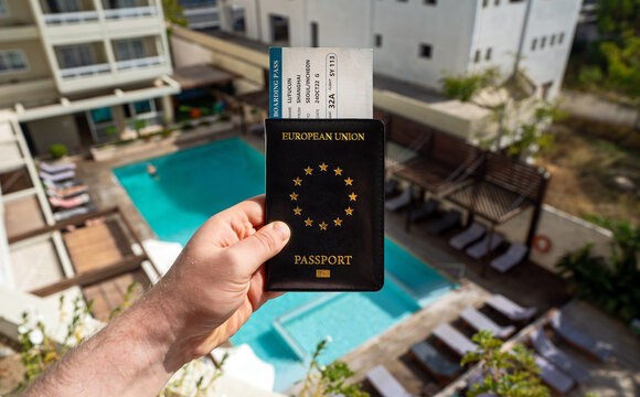 Man holding European passport and airline ticket.