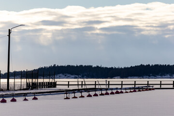 Dalaro, Sweden A small boat dock with red buoys with no boats in the ice on the Baltic Sea.
