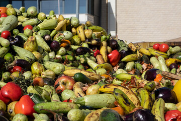 Heap of Mix expired Vegetables and fruits at harvest time. Organic bio waste in a huge container,...