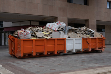 huge heap on metal Big  Overloaded dumpster waste container filled with construction waste, drywall...