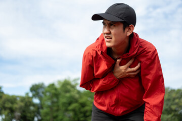 Young asian indian man tired during jogging on the track in sport stadium. Young asian male intense training workout challenge breathing exhausted. Healthy and active lifestyle concept.