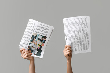 Women with newspapers on grey background