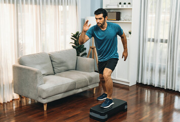 Fototapeta na wymiar Athletic and sporty man running posture at home body workout exercise session for fit physique and healthy sport lifestyle at home. Gaiety home exercise workout training.