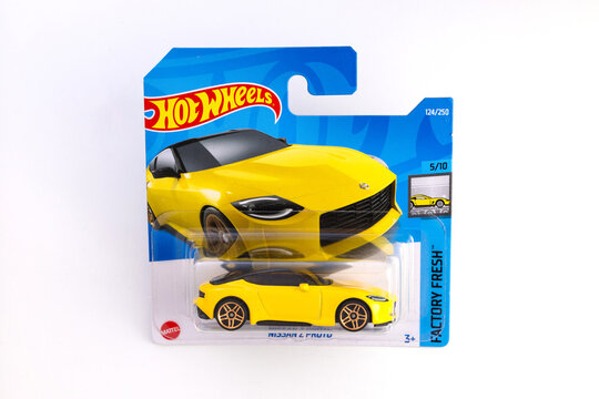 Warwick, UK - Feb 8 2023 : Close up hot wheels Nissan Z Porto Japanese yellow toy limited edition 1:43 die cast car in unopened packaging white background graphic design resource. 