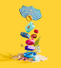 Summer accessories stacked high. Pink flamingo with travel luggage and beach accessory on yellow background. 3D Rendering, 3D Illustration