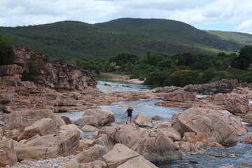 mulher caminhando em pedras no Rio Paraguaçu em Andaraí, na Chapada Diamantina, Bahia