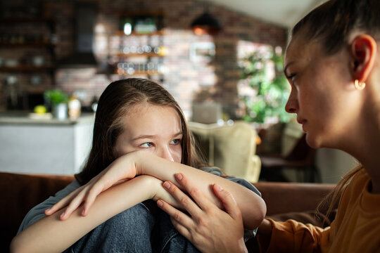 Mother comforting a sad daughter at home