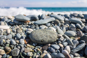 Beach stones and pebbles in front of the sea and sky
