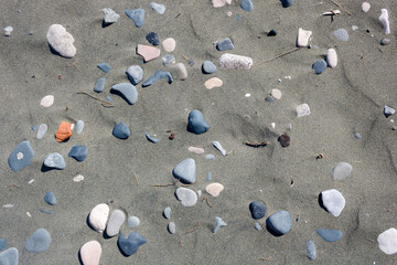 Dry stones and pebbles on gray sand background