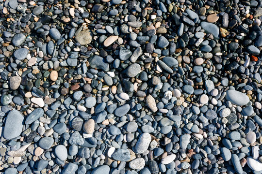 Wet and dry beach stones and pebbles background
