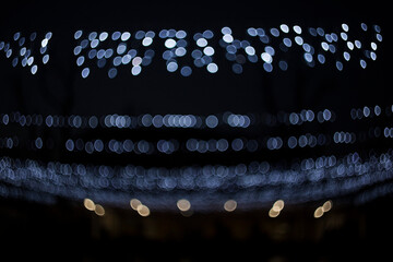 Abstract blur of blue and yellow lights on a black background. Wonderful blue light bokeh background on a dark background.