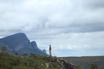 homem em trilha na Chapada Diamantina, Bahia, com motanhas ao fundo