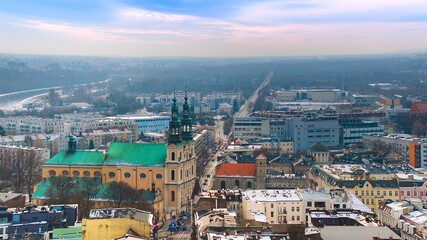 Aerial view of Poznań's historic market square in winter, showcasing the charming old townhouses...
