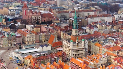 Aerial view of Poznań's historic market square in winter, showcasing the charming old townhouses...